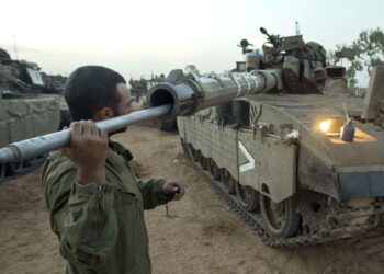 Israelilaissotilas puhdistamassa panssarivaunun tykkiä lähellä Gazan rajaa tiistaina.