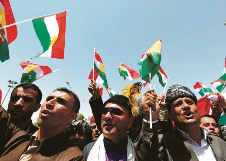 Kurdilippuja heiluttavat miehet osoittivat kannatustaan itsenäisyyspyrkimyksille Irakin Kurdistanin itsehallintoalueen parlamentin edessä Erbilissä heinäkuun alussa.