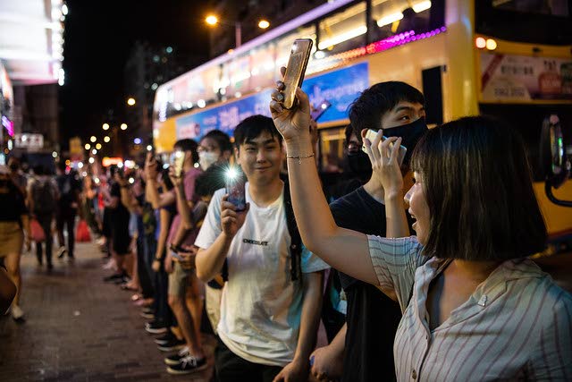Hongkongilaisia osoittamassa mieltään puhelintensa avustuksella.