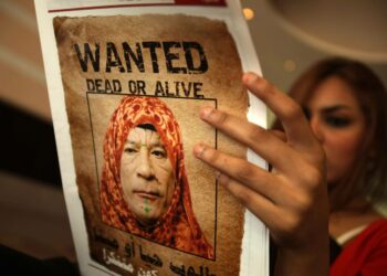 Libyalaisen Arus al-Bahr -lehden kannessa on halventavasti naisen asuun puettua Muammar Gaddafia kuvaava ”etsintäkuulutus”.