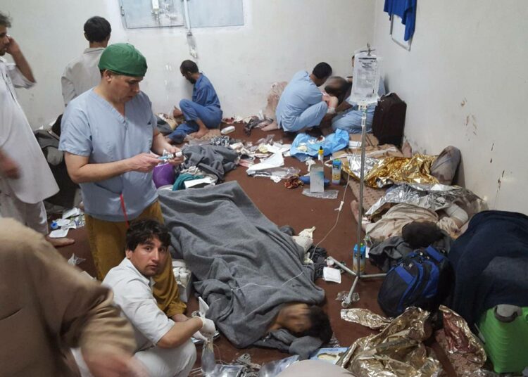 MSF:n työntekijät hoitamassa haavoittuneita kollegoitaan ja potilaitaan sairaalan säilyneessä osassa keskiviikkona.