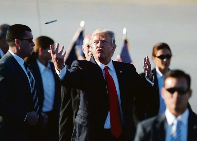 Presidentti Donald Trump heitti kynän ilmaan kirjoitettuaan kannattajalleen nimikirjoituksensa Palm Beachin lentokentällä Floridassa.