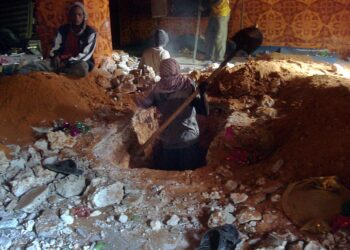 Shabab-joukkojen mies kaivamassa haudasta vääräoppisena pidetyn, 30 vuotta sitten kuolleen maltillisen muslimioppineen ruumista Mogadishussa.