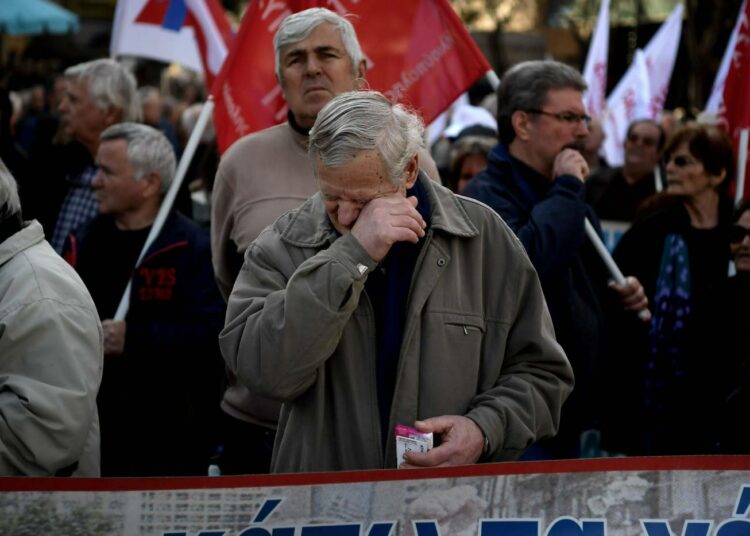 Mies pyyhki kyyneleitä lakkolain muuttamista vastustaneessa mielenosoituksessa Ateenassa perjantaina.