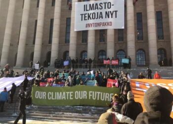 Greenpeacen kiipeilijät ripustivat eduskuntatalon pylväisiin banderollin. Kuvakaappaus Greenpeacen videosta.