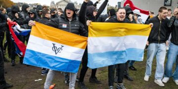 Maahanmuuttajien vastainen mielenosoitus Amsterdamissa lokakuussa. Vasemmanpuoleinen lippu on siirtomaavallan aikainen, 1600-luvulta peräisin oleva Hollannin Itä-Intian kauppakomppanian lippu.