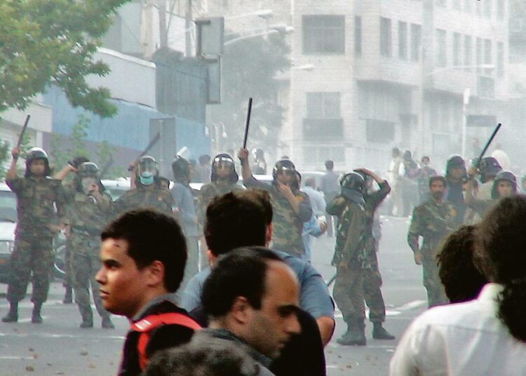 Mielenosoittajia ja mellakkapoliisin rivistö Teheranissa lauantaina.