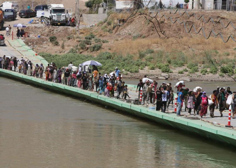 Jesidipakolaisia maanantaina Syyrian ja Irakin rajalla sijaitsevalla Fishkhaburin sillalla.