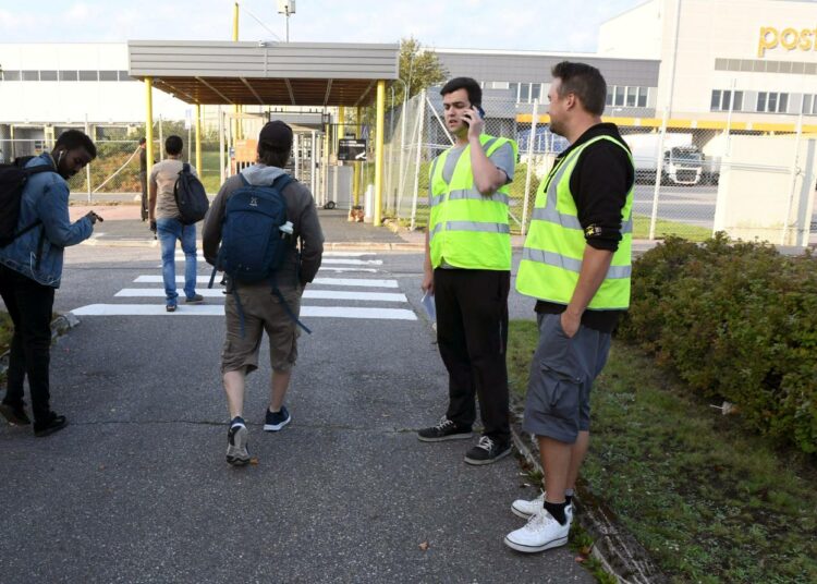 Lakkovahdit Mika Kemppi (oik.) ja Filip Jorsevich Postin logistiikkakeskuksen edustalla Vantaan Tikkurilassa maanantaiaamuna.