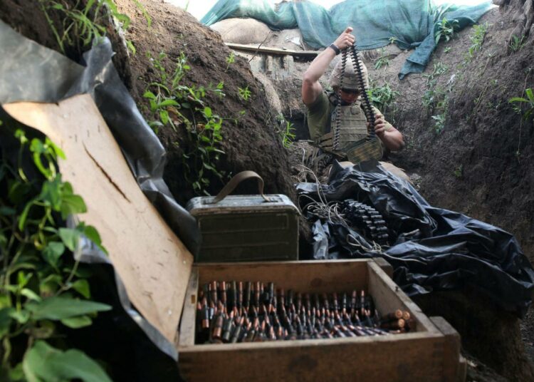 Ukrainalaissotilas lataa aseita Donetskin alueella.