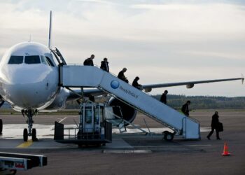 Matkustajia saapui lennolla Tikkakosken lentoasemalle Jyväskylässä torstaina. Esimiehet käsittelivät matkatavarat.