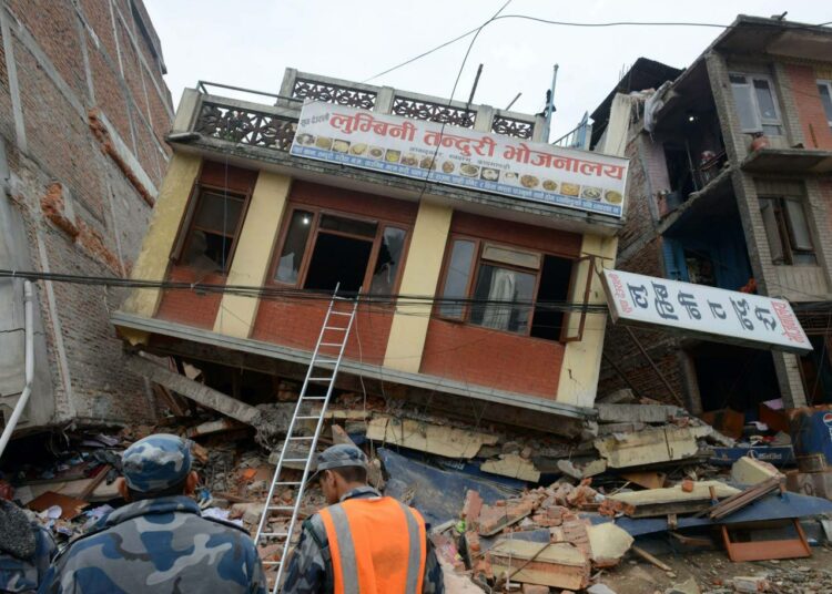 Pelastustyöntekijöitä tutkimassa tuhoutuneita rakennuksia Kathmandussa sunnuntaina.