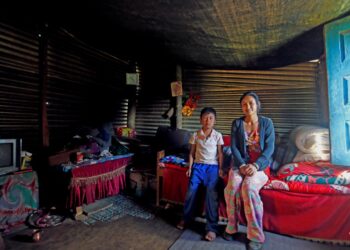 Nepalilainen Priya Tamang tilapäisen kotinsa edustalla.