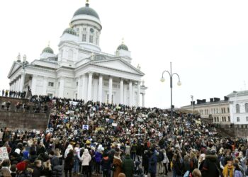 Nuoria mielenosoittajia Tuomiokirkon portailla ennen kansainvälisen nuorten ilmastolakon marssia Helsingissä perjantaina 15. maaliskuuta.