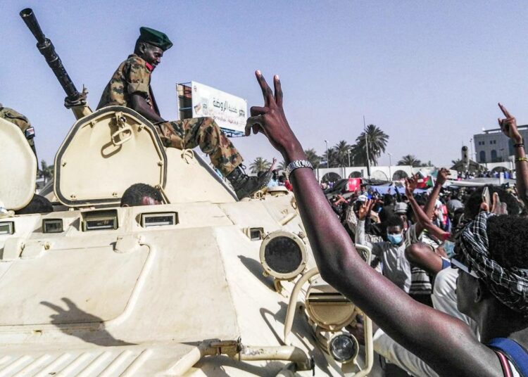 Mielenosoittajat tervehtivät sotilaita Khartumin keskustassa tiistaina.