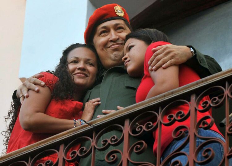 Hugo Chávez näyttäytyi maanantaina presidentinpalatsin parvekkeella kainalossaan tyttärensä Maria ja Rosa.