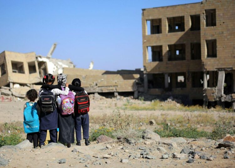 Jemeniläiset koulutytöt katselivat ilmahyökkäyksessä vaurioitunutta koulua maaliskuussa Taezissa.
