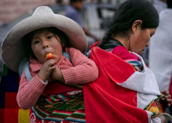 Nuori ketšua-äiti Perun pääkaupungin Liman kadulla kantaa selässä tytärtään. Neljännes Perun maaseudulla asuvista alle viisivuotiaista lapsista kärsii kroonisesta aliravitsemuksesta.