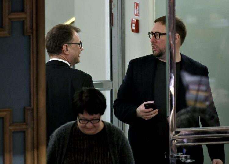 Keskustan Juha Sipilä ja vasemmistoliiton Paavo Arhinmäki menossa eri suuntiin eduskunnan istuntosalin ovella. Vaalien  jälkeen he voisivat olla samassa hallitusjoukkueessa.