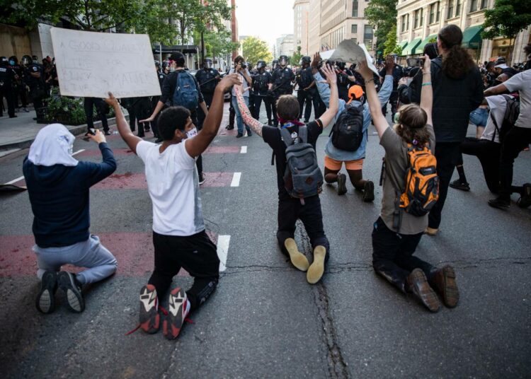 Mielenosoittajia poliisiketjun edessä Washingtonissa sunnuntaina.