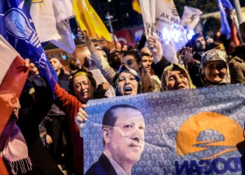 AKP-puolueen kannattajat juhlivat sunnuntai-iltana Istanbulissa presidentti Recep Tayyip Erdoganin kuvia kantaen.