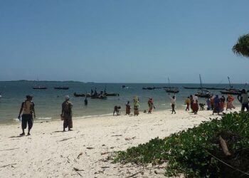 Asukkaat odottavat kalastajia palaaviksi Kenian Gasi Beachilla Intian valtameren rannalla. Kalansaalit ovat kutistuneet ilmastonmuutoksen seurauksena.