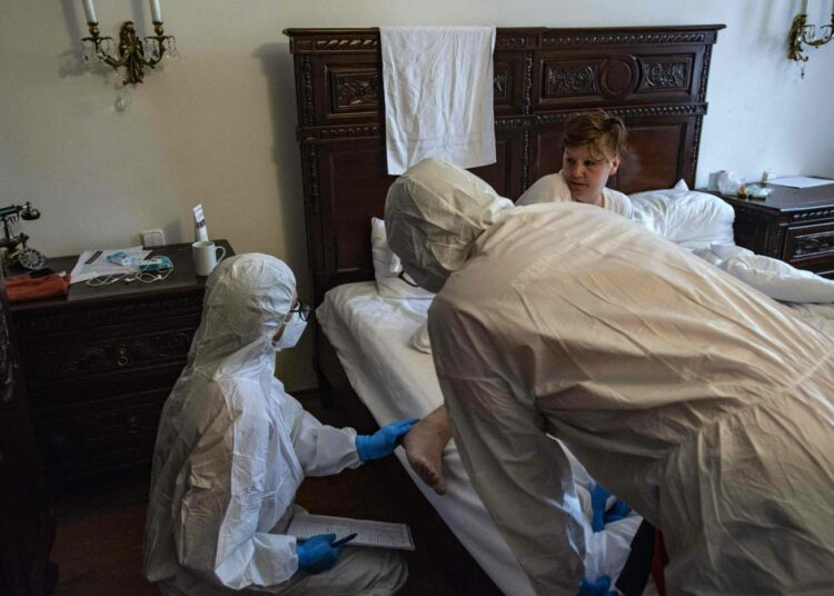 Tshekeissä rokotevastaistuus on suurta. Kuvassa hoidetaan koditonta koronaviruspotilasta prahalaisessa hotellihuoneessa.