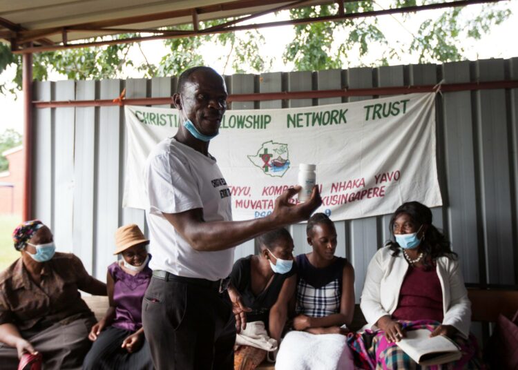 Reki Jimu on elänyt hiv-positiivisena jo lähes kaksi vuosikymmentä. Kuvassa hän esittelee antiretroviraalilääkepurkkia hiv/AIDS -tukiryhmälle Chitungwizan sairaalassa.