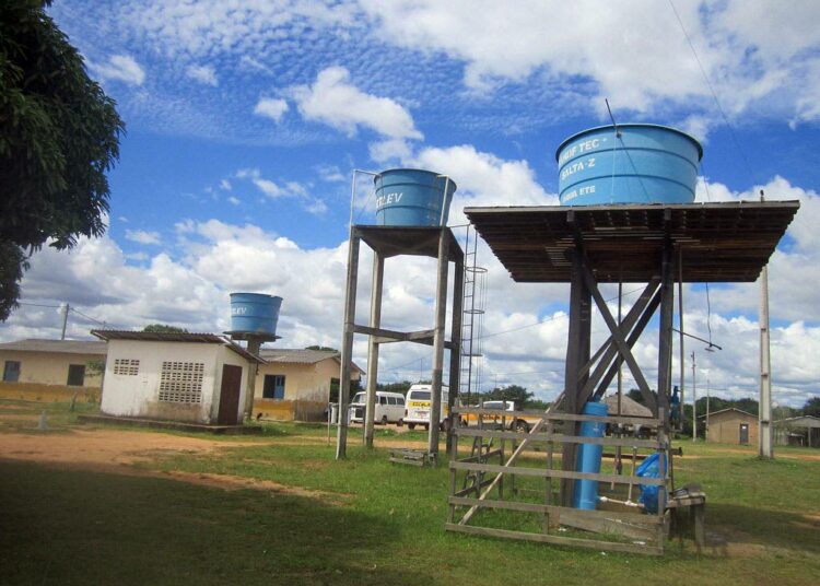 Daroran vesisäiliöt, joista yhdessä on kemiallisesti juomakelpoiseksi tehtyä vettä. Veden pumppaaminen säiliöihin ja peltojen kasteluun tulee kalliiksi, mutta aurinkoenergia olisi ilmaista. Taaempana macuxi-yhteisöä palveleva koulu.