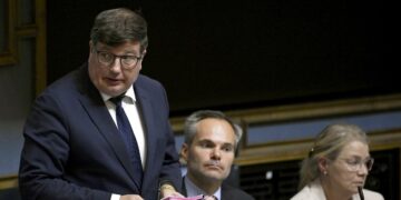 Työministeri Arto Satonen (kok.) puhuu eduskunnan täysistunnossa kesäkuussa. Vieressä istuvat ympäristö- ja ilmastoministeri Kai Mykkänen (kok.) ja oikeusministeri Leena Meri (ps).