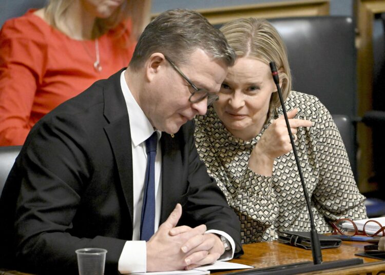 Pääministeri Petteri Orpo (kuvassa vas.) ja valtiovarainministeri Riikka Purra keskustelivat eduskunnan täystunnossa.