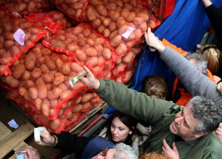Asiakkaat ostavat halpoja perunoita suoraan viljelijöiden autosta Thessalonikissa. Sekä kuluttajat että tuottajat ovat olleet tympääntyneitä rahojen valumisesta välikäsille.