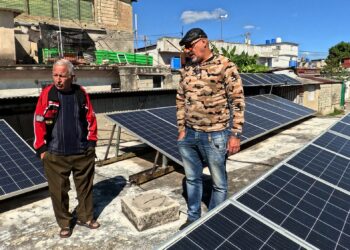 Yrittäjät Félix Morffi ja Néstor Pérez havannalaisen asuinrakennuksen katolla, jonne on asennettu aurinkopaneeleja.