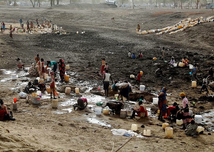 Sudanista väkivaltaa paenneet ihmiset etsivät vettä Jamamin pakolaisleirissä Etelä-Sudanin puolella keväällä 2012. Nyt lähes miljoona eteläsudanilaista on paennut nälkää ja väkivaltaa Ugandaan.