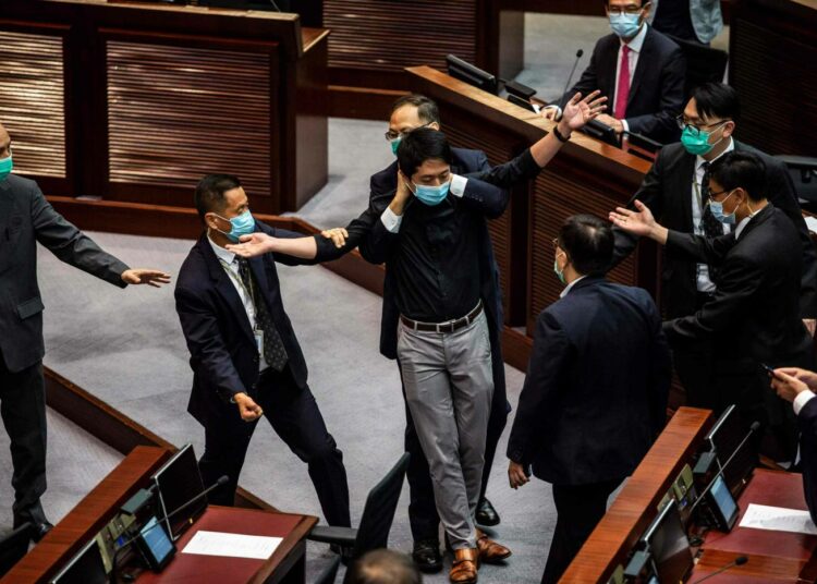 Heinäkuisessa protestissa opposition Ted Hui (kuvassa keskellä), Ray Chan ja Eddie Chu heittivät mädän kasvin ja pahalta haisevaa lannoitetta Hongkongin alueparlamentin istuntosalissa, jotta saisivat keskeytettyä lakiehdotuksen käsittelyn.