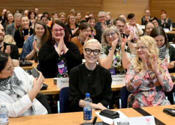 Kilpailevat ehdokkaat Gashaw Bibani (vas.) ja Laura Meriluoto (oik.) sekä muu puoleväki antoivat aplodit uudeksi puheenjohtajaksi valitulle Minja Koskelalle.