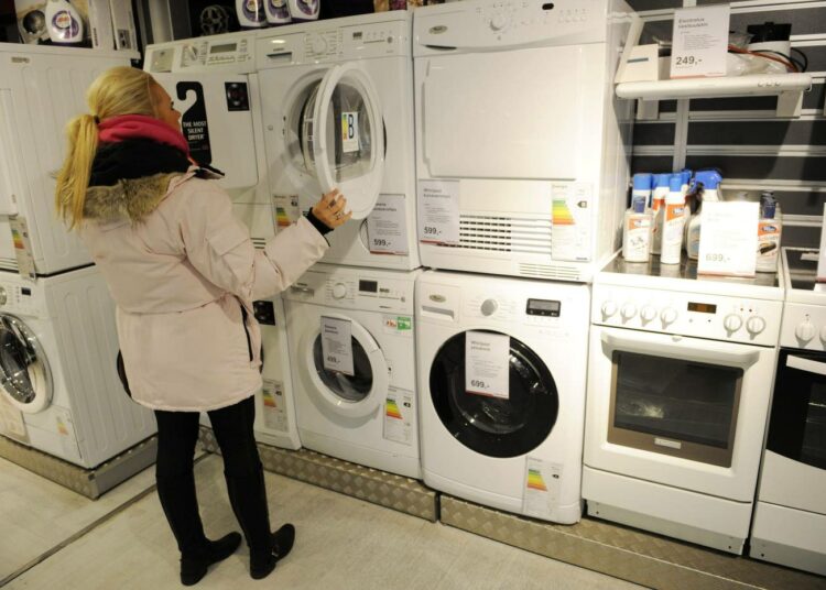 Nainen ostoksilla kodinkoneliikkeessä.