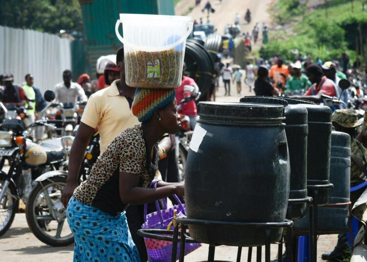 Kongon demokraattisesta tasavallasta saapuvia ihmisiä pesemässä käsiään Ugandan Mpondwessa, jossa tehtävillä tarkastuksilla pyritään estämään ebolan leviäminen.