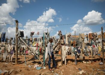Mies katseli joukkohaudoista esiin kaivettujen kansanmurhan uhrien narulle ripustettuja vaatteita Ruandan pääkaupungin Kigalin laitamilla huhtikuussa.