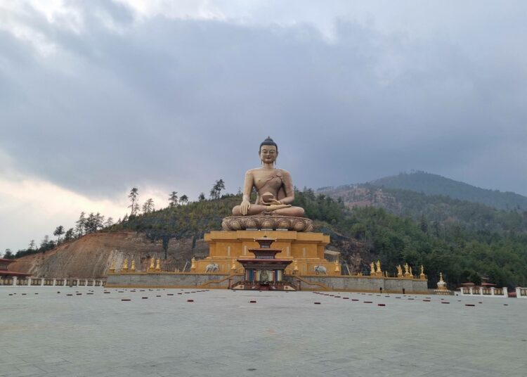 Jättiläismäinen Buddhan patsas Bhutanin vuorilla, Suuri Buddha Dordenma. Buddhalainen Bhutan on maailman ainoa hiilinegatiivinen maa, mutta silti haavoittuvainen ilmastonmuutoksen seurauksille.