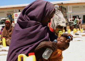 Äiti juottaa lastaan ruoanjakelupisteessä Mogadishussa, Somaliassa.