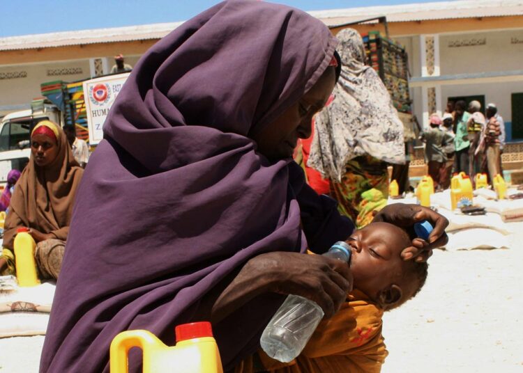 Äiti juottaa lastaan ruoanjakelupisteessä Mogadishussa, Somaliassa.