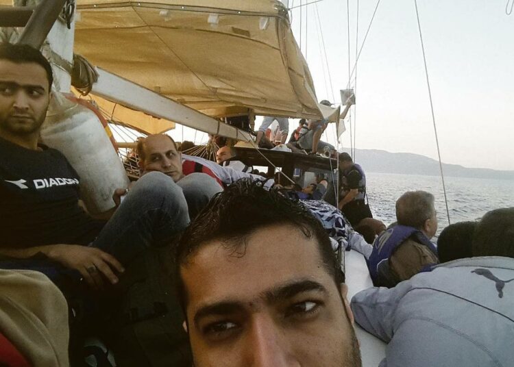 Ali (edessä) veneessä matkalla Turkin Bodrumista Kreikkaan. Veneessä oli 140 ihmistä, eikä kaikille riittänyt istumapaikkaa.