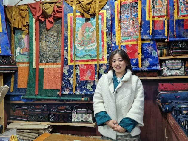 Tshering Lhamo kaupassaan, jossa hän myy käsinmaalattuja thangka-kankaita. Lhamo arvostaa erityisesti Himalajan ilman puhtautta.