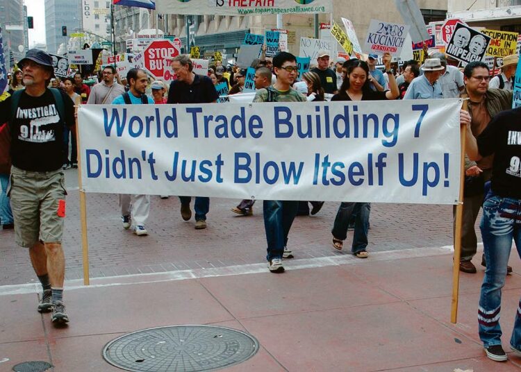 911-totuusliikkeen mielenosoittajat Los Angelesissa vaativat kunnollista tutkimusta syyskuun 11. päivän tapahtumien lukuisista epäselvyyksistä. World Trade Centerin rakennus 7 ei räjähtänyt itsestään, banderollissa todetaan.