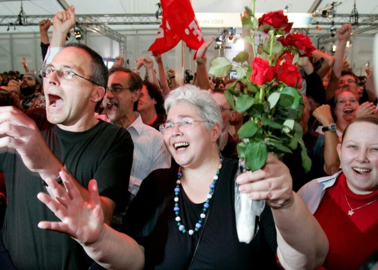 Vasemmistopuolue die Linken kannattajia juhlimassa vaalivoittoa sunnuntai-iltana Berliinissä.
