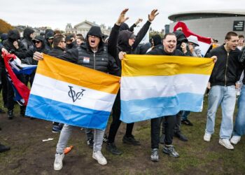 Maahanmuuttajien vastainen mielenosoitus Amsterdamissa lokakuussa. Vasemmanpuoleinen lippu on siirtomaavallan aikainen, 1600-luvulta peräisin oleva Hollannin Itä-Intian kauppakomppanian lippu.