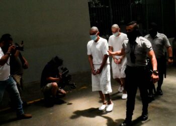 Jengijäsenyydestä epäilty vanki siirretään selliin terrorismin eristyskeskuksessa El Salvadorin keskiosassa. Kuva on otettu yhdellä harvoista toimittajavierailuista tähän korkean turvallisuustason vankilaan. Monet syytetyt joutuvat odottamaan vuosia ennen yhteistä oikeudenkäyntiä.