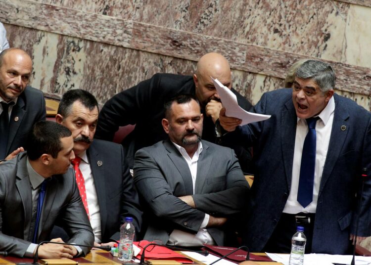 Kultaisen aamunkoiton johtaja Nikos Michaloliakos (oik.) puhumassa parlamentin istunnossa kesäkuussa.
