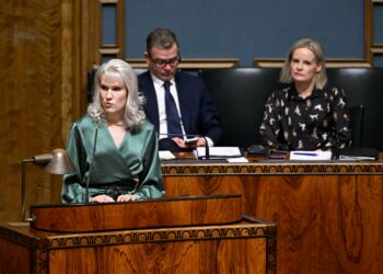 Vasemmistoliiton Jessi Jokelainen puhuu, pääministeri Petteri Orpo (kok.) ja valtiovarainministeri Riikka Purra (ps.) kuuntelevat.